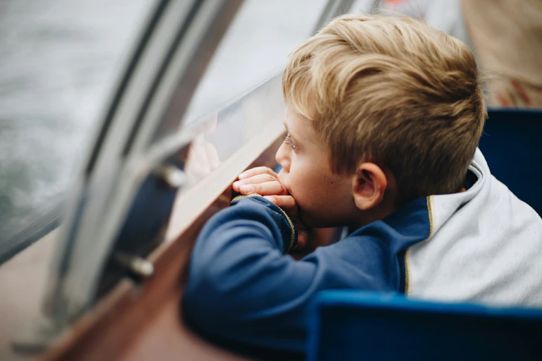 Un enfant regarde par la fenêtre.