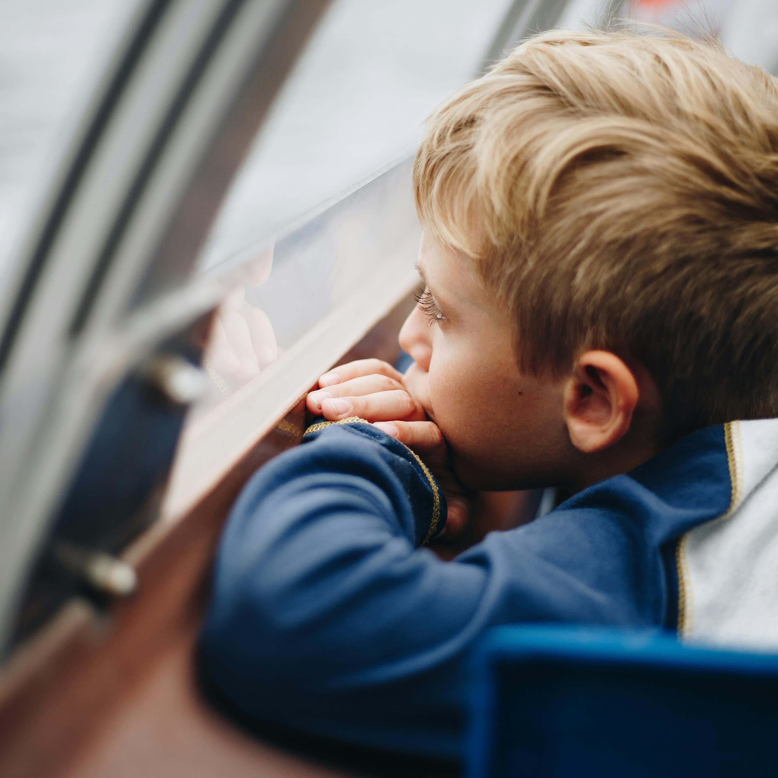 Un enfant regarde par la fenêtre.