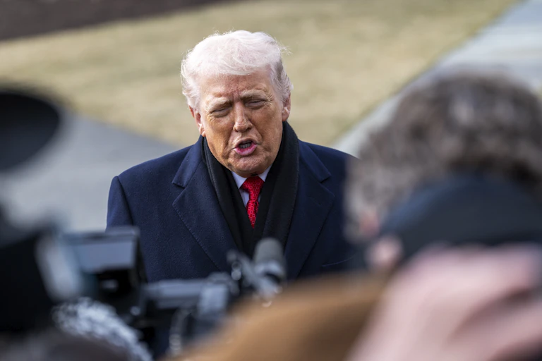 Donald Trump responds to questions from reporters on the White House lawn.