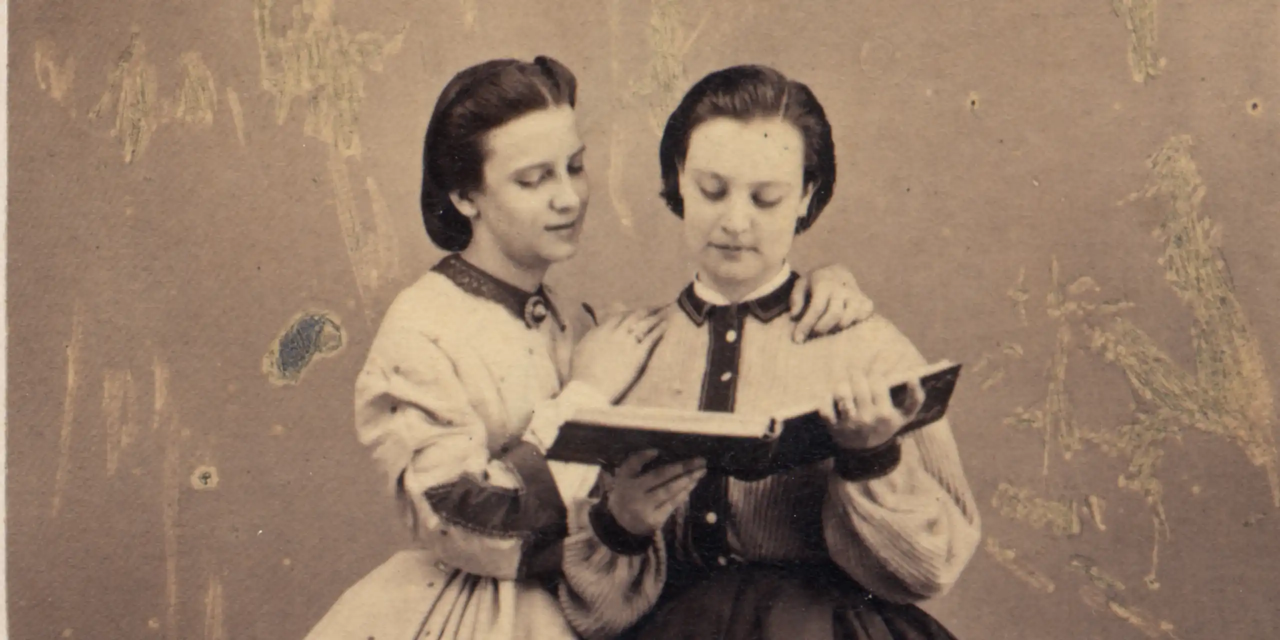 Dos mujeres del siglo XIX leen un libro.