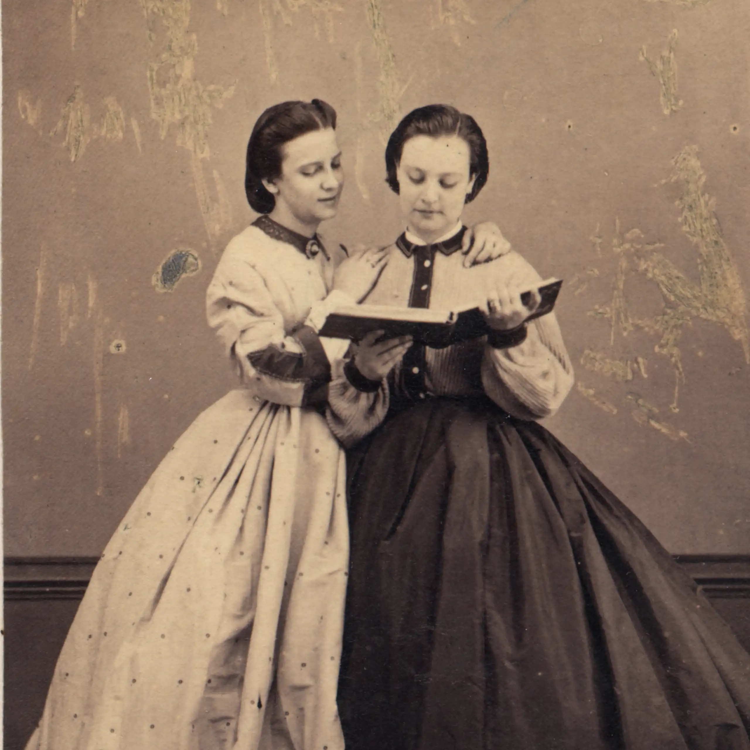 Dos mujeres del siglo XIX leen un libro.