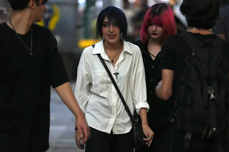 Young Iraniam women walking in the street without wearing the hijab.