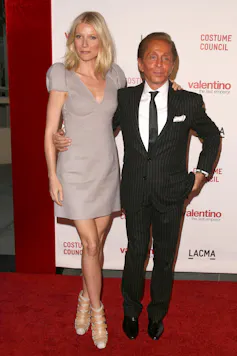 Una mujer rubia alta y un hombre de traje muy bronceado.