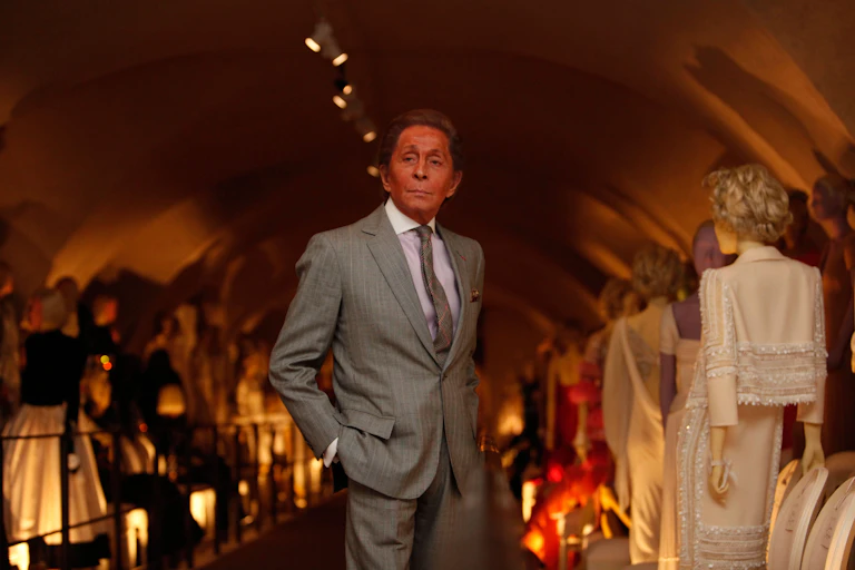 Valentino Garavani surrounded by his designs.