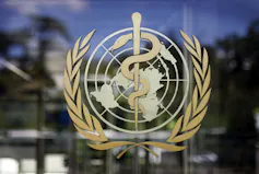 A round logo with a globe, a caduceus and a wreath on a window