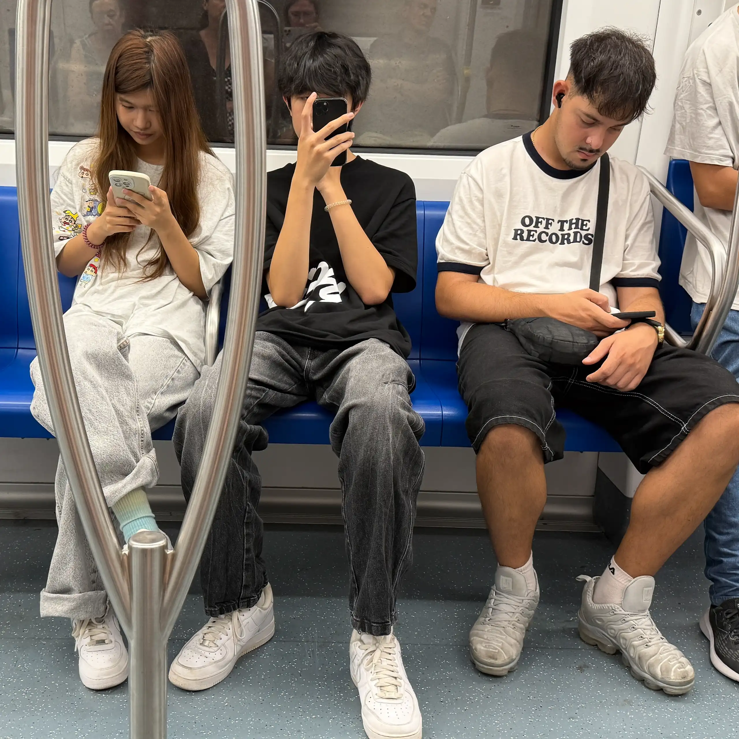 Pasajeros en el metro centrados en sus teléfonos móviles.