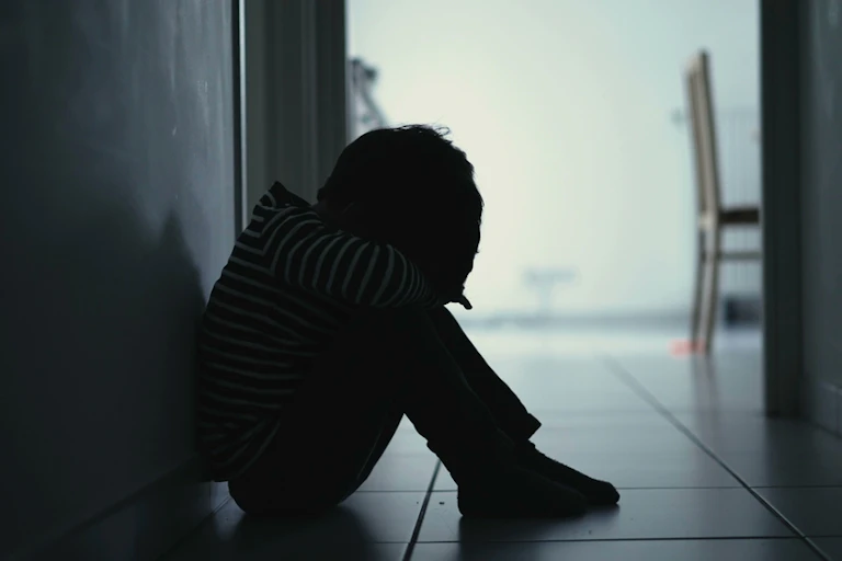Un enfant assis dans un couloir