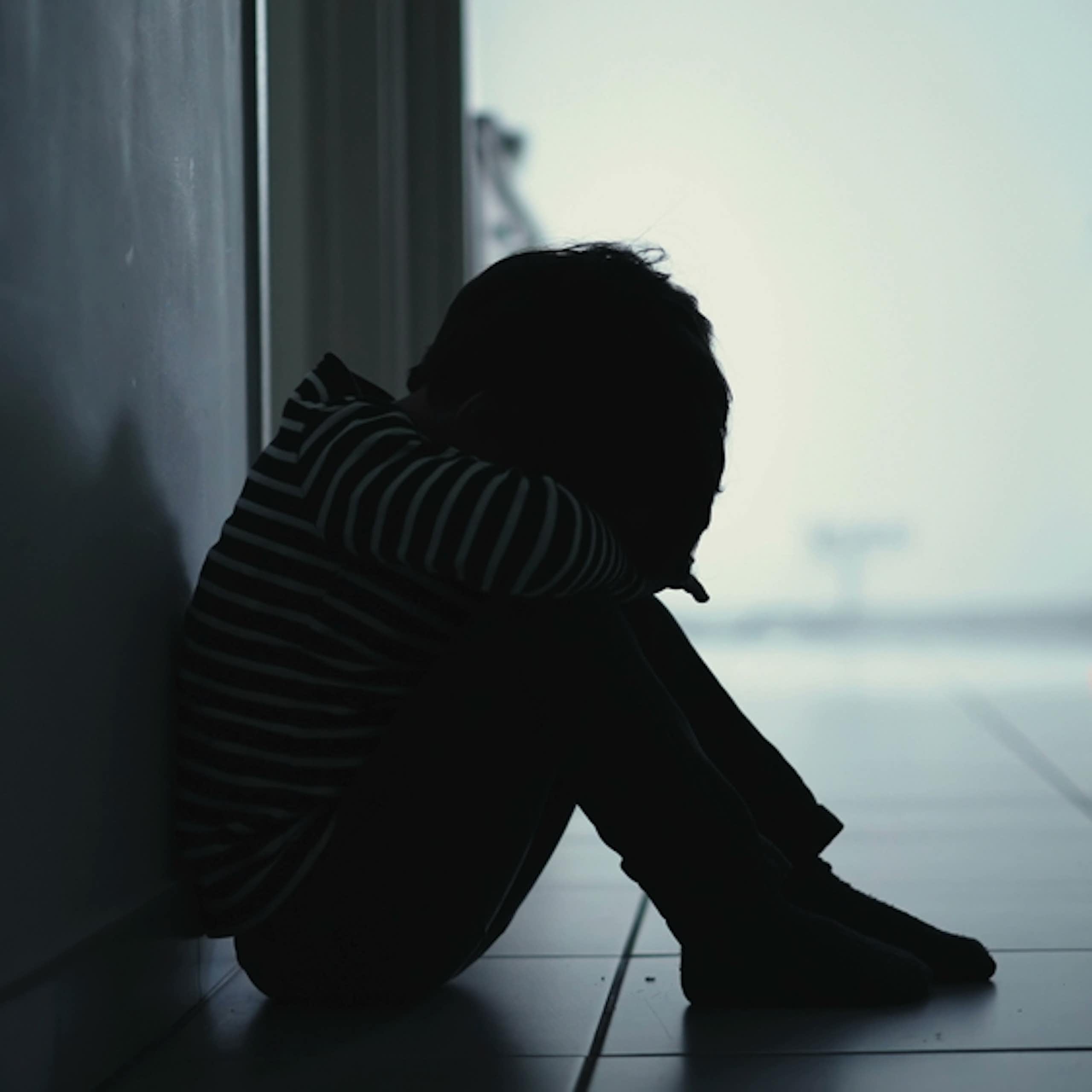 Un enfant assis dans un couloir