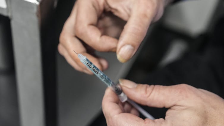 primer plano de una jeringa en las manos de una persona