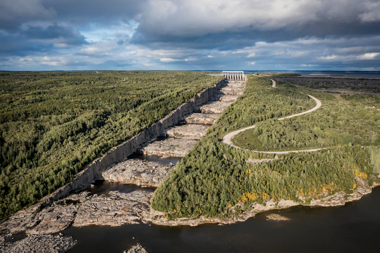 A power station with a dry spillway leading to it.