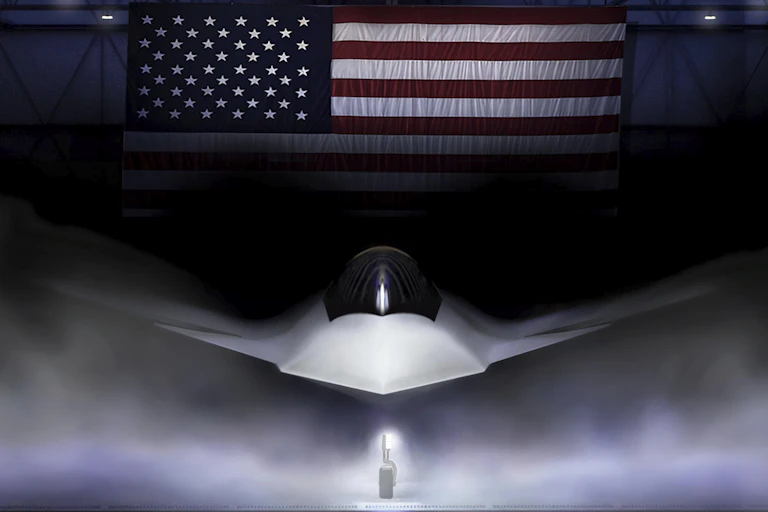 A sleek white plane in a hanger decorated with an American flag.