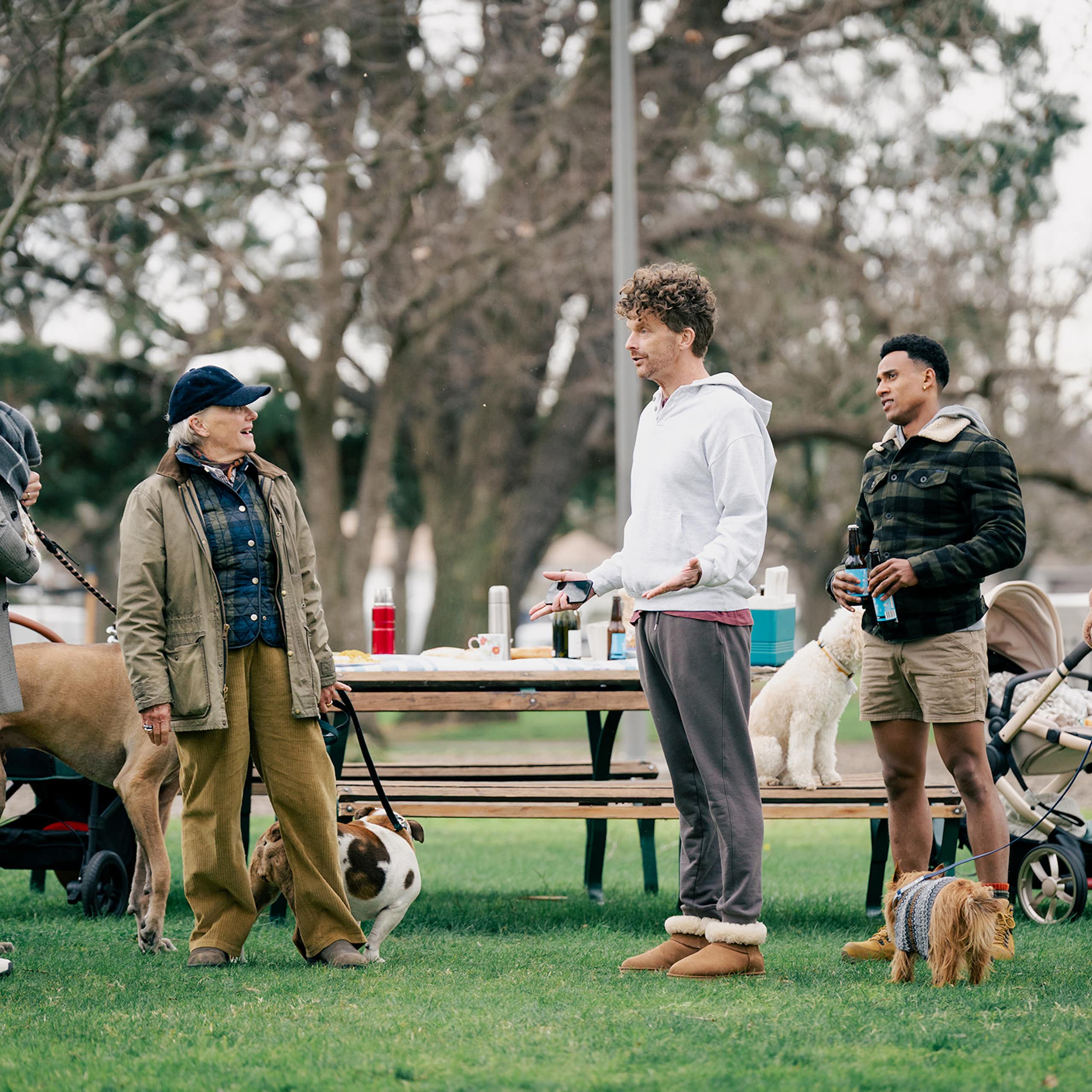 Production image: a group of people in a park, with their dogs.