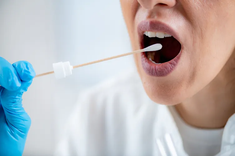 A swabbing their mouth.