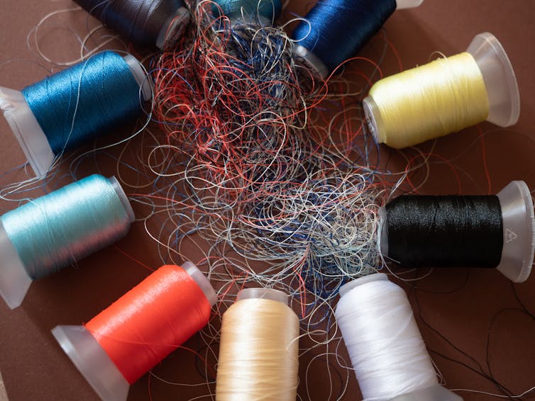 Spools of coloured embroidery threads. Huge knot is haphazardly braided.
