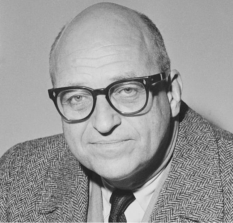 James Roosevelt wearing a suit and glasses.