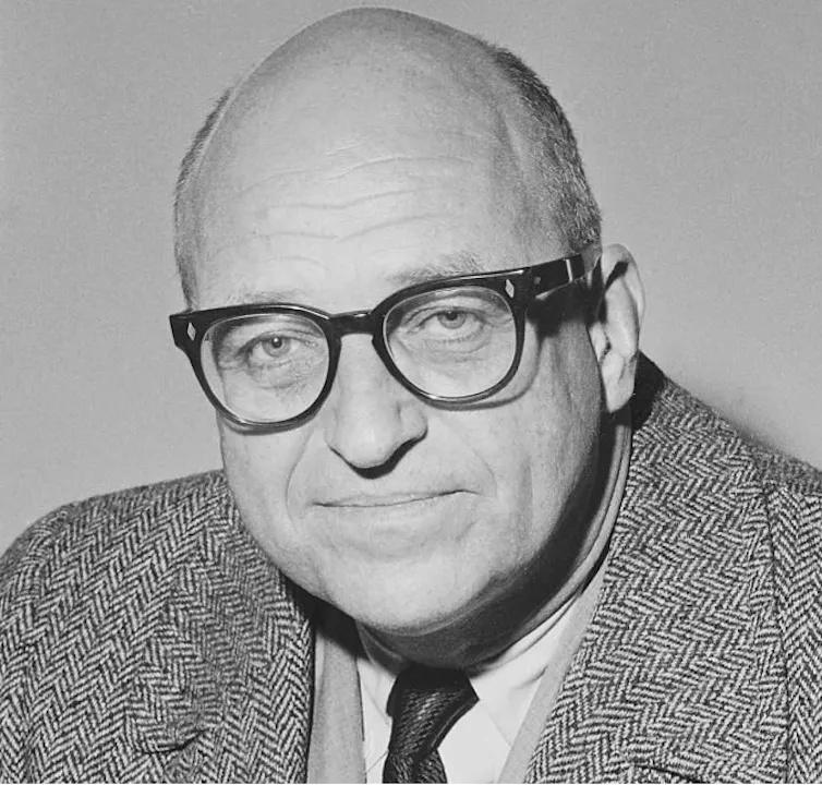 James Roosevelt wearing a suit and glasses.