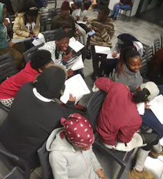 Young people sitting and writing