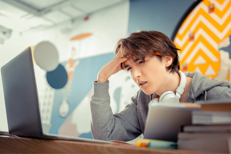 Boy squinting at computer screen