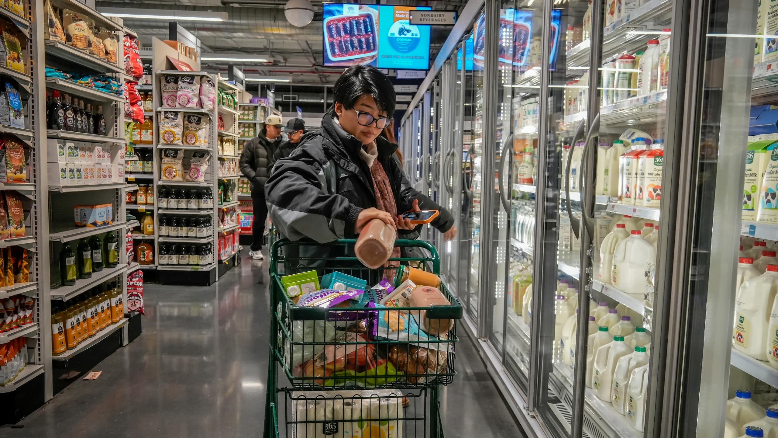 A customer filling a shopping cart in a supermarket in New York.