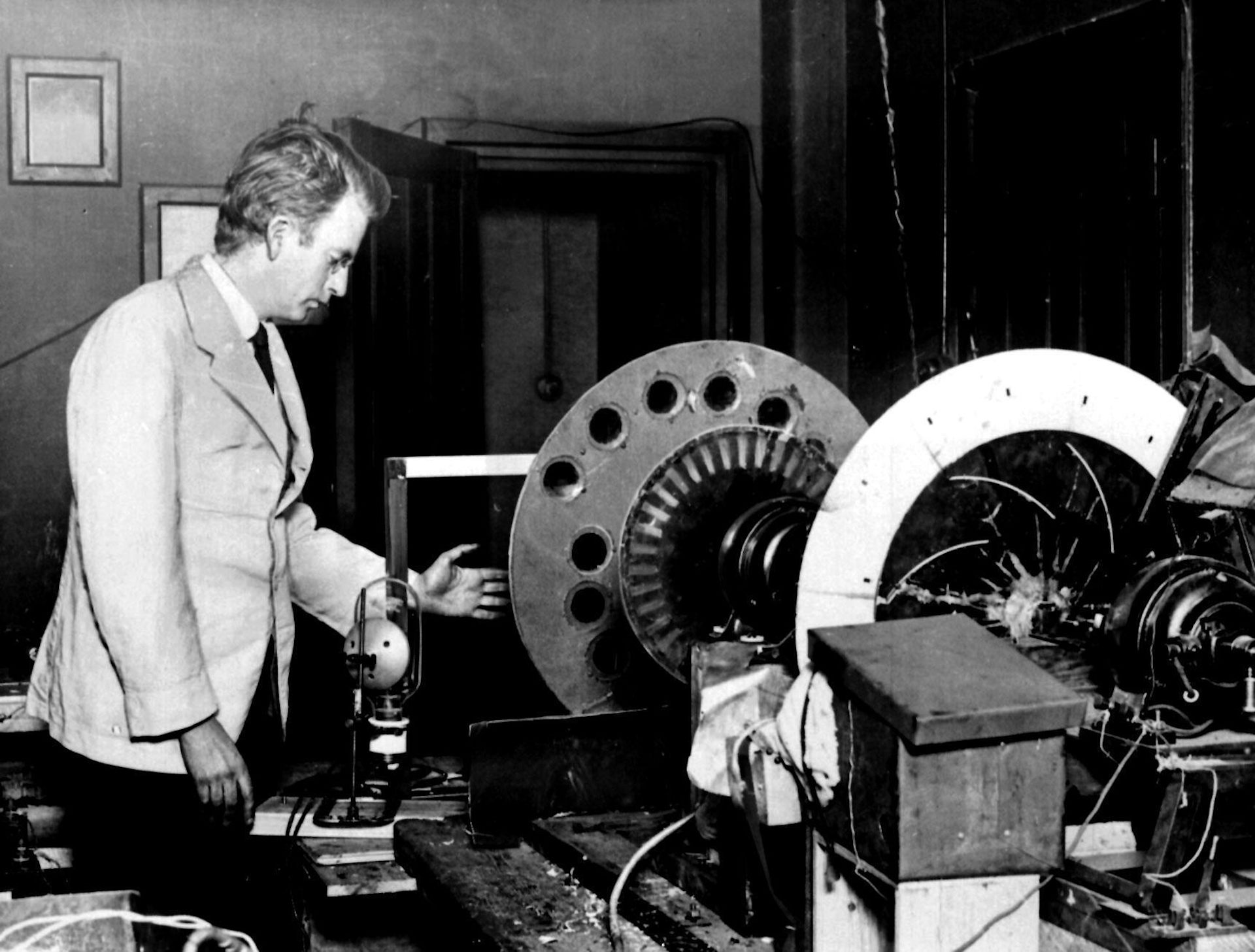 John Logie Baird standing next to his machine for demonstrating mechanical television.