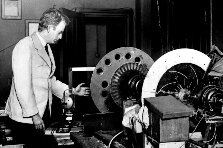 John Logie Baird standing next to his machine for demonstrating mechanical television.