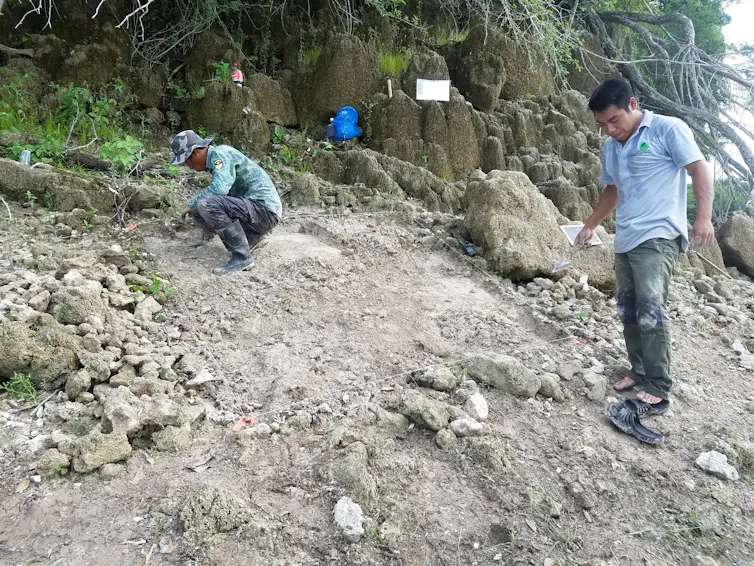 men focused on rocky bare dirt