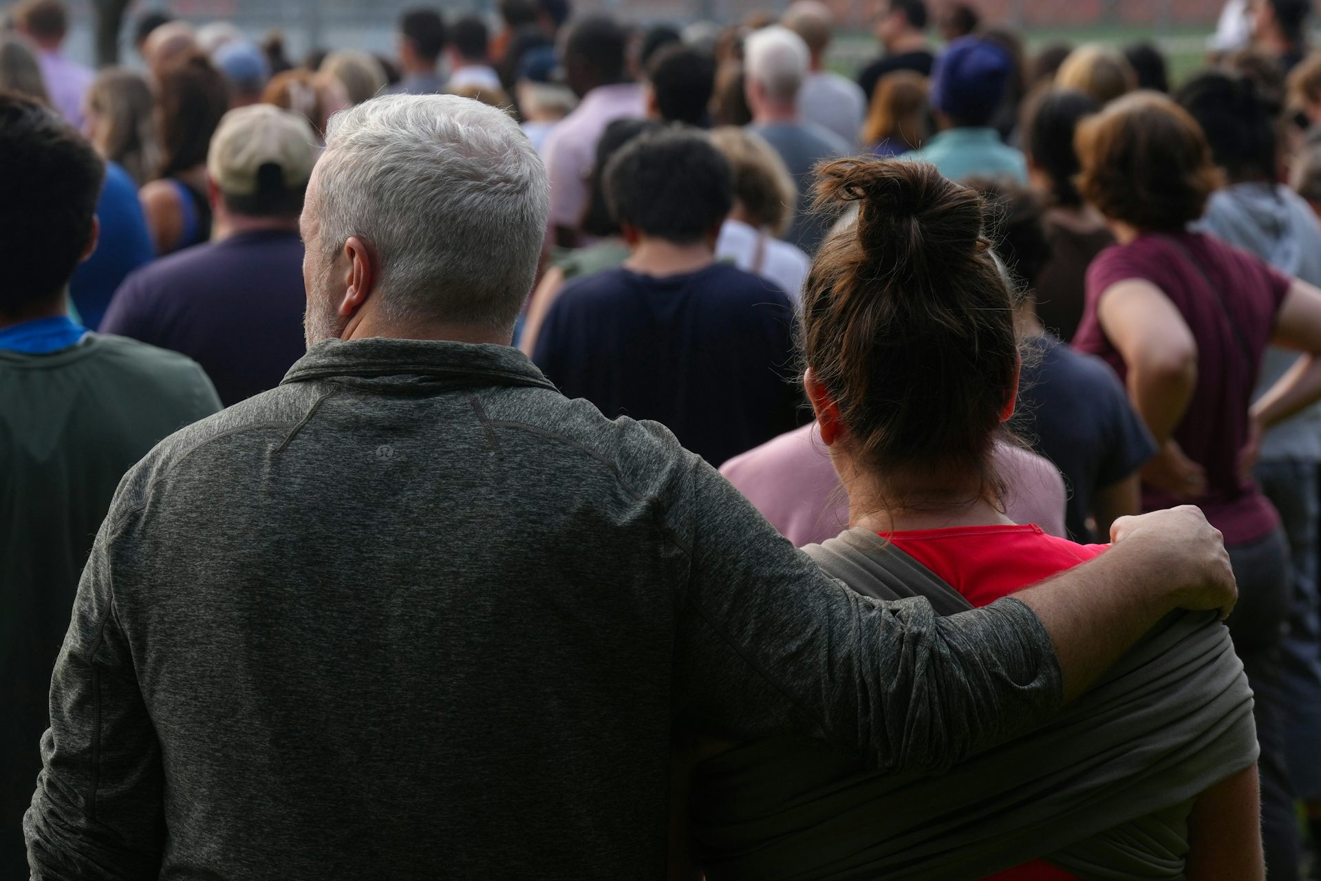a man and woman among a group of people photographed from behind 