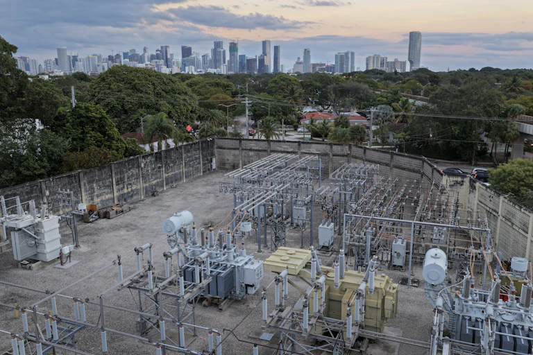 electrical utility equipment in the foreground and a city skyline in the background