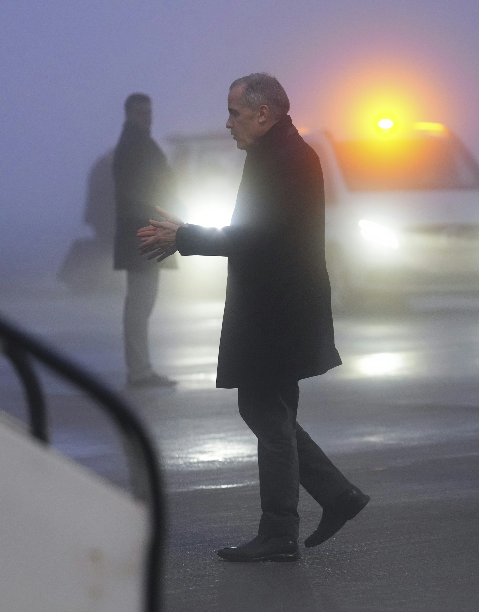 A thin man is seen in profile at dusk getting into a plane