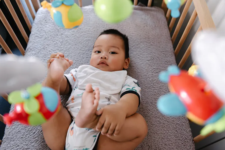 baby in crib looks up toward camera