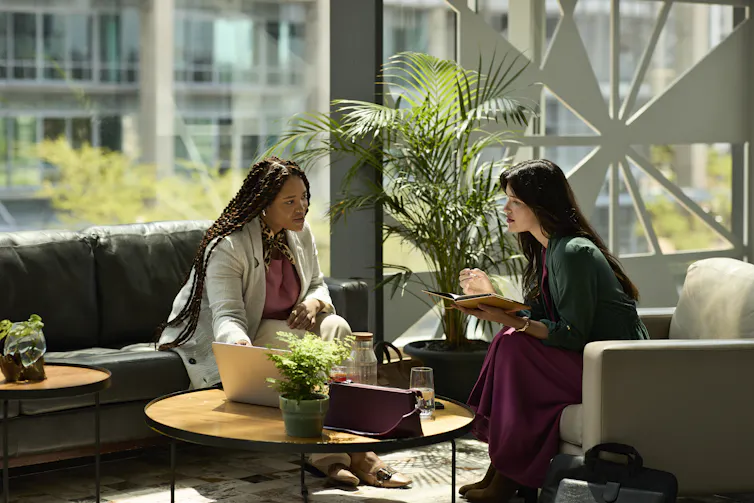 two women in discussion sitting on couches