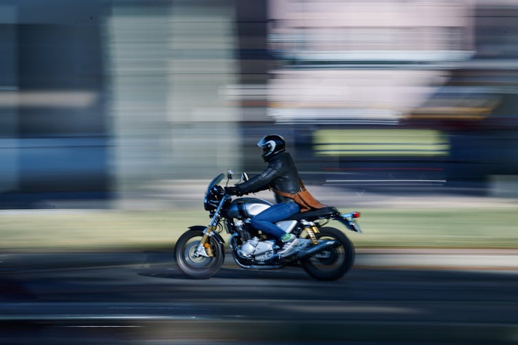 A motorcyclist against a blurred background.