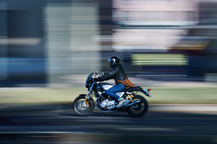 A motorcyclist against a blurred background.