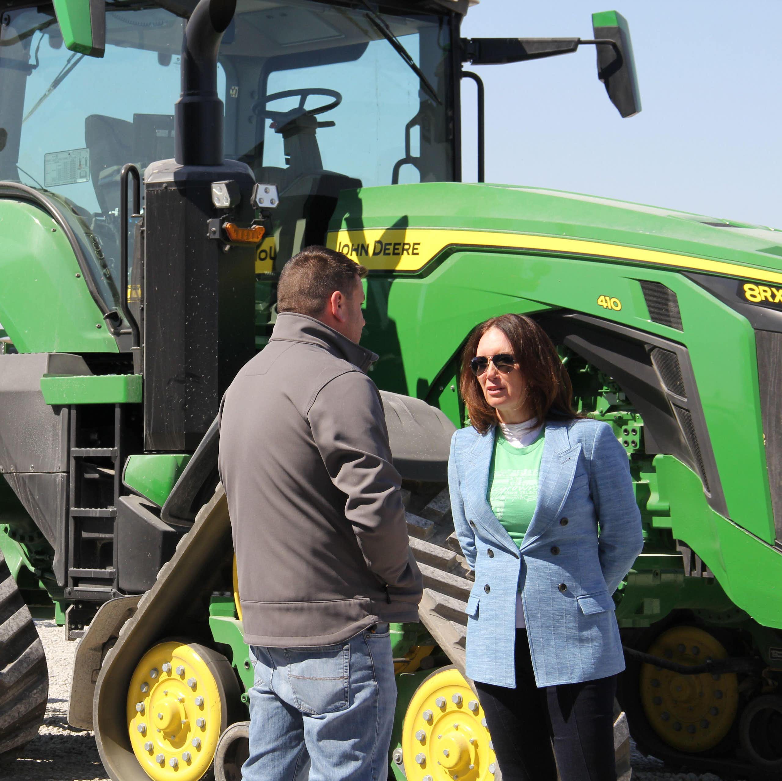 US agriculture secretary, Brooke Rollins, talks to a pig farmer in Iowa in front of his tractor, March 2025.
