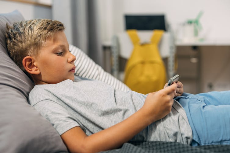 Boy on sofa looking at phone