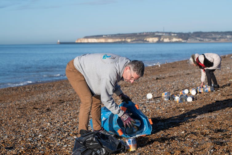 people picking up stuff on beach