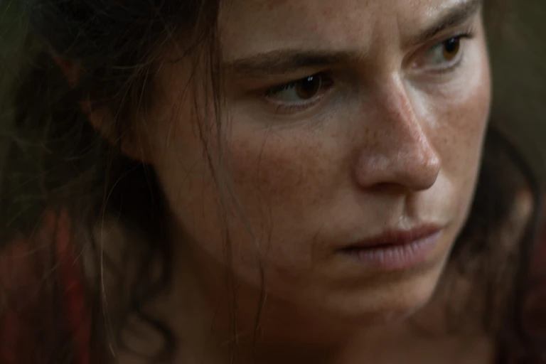 A woman stares pensively.
