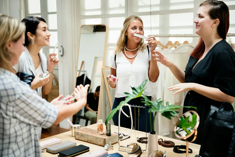 A group of people in a perfume store sampling.