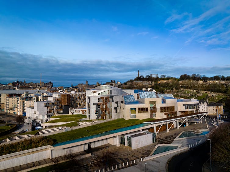 exterior shot of the scottish parliament building in edinburgh with wider cityscape in the background.