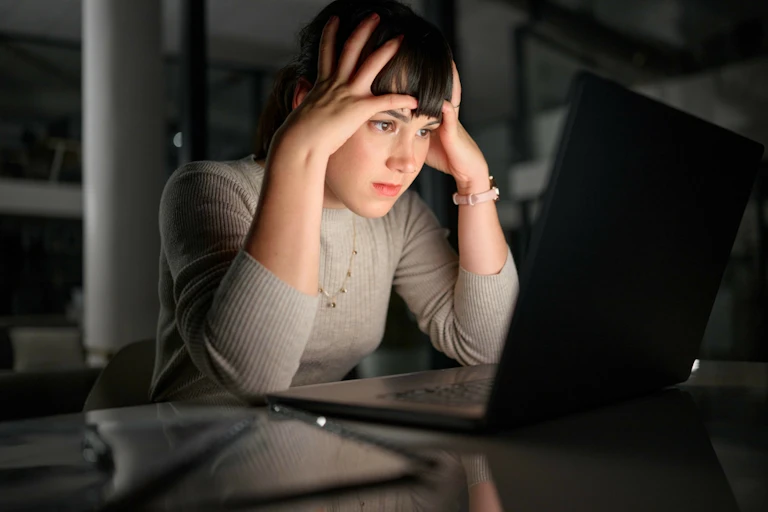 Une femme qui essaie de comprendre des informations affichées sur un écran d'ordinateur.