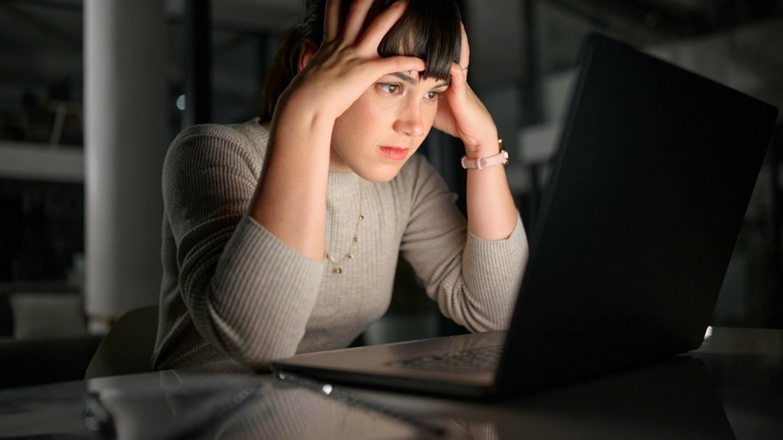Une femme qui essaie de comprendre des informations affichées sur un écran d'ordinateur.