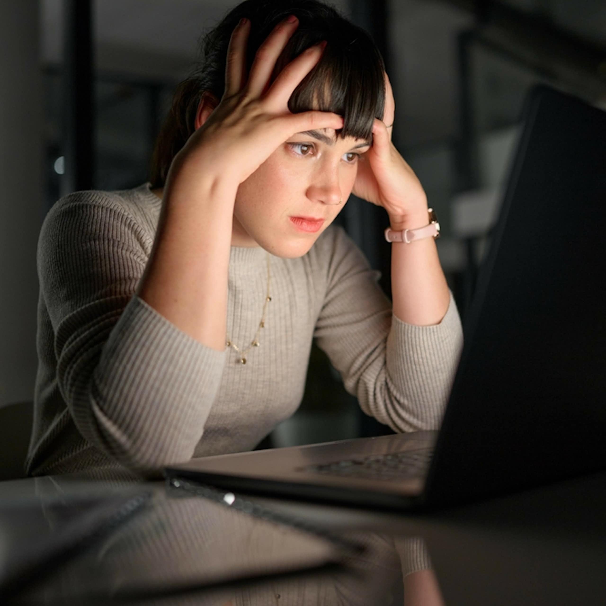 Une femme qui essaie de comprendre des informations affichées sur un écran d'ordinateur.