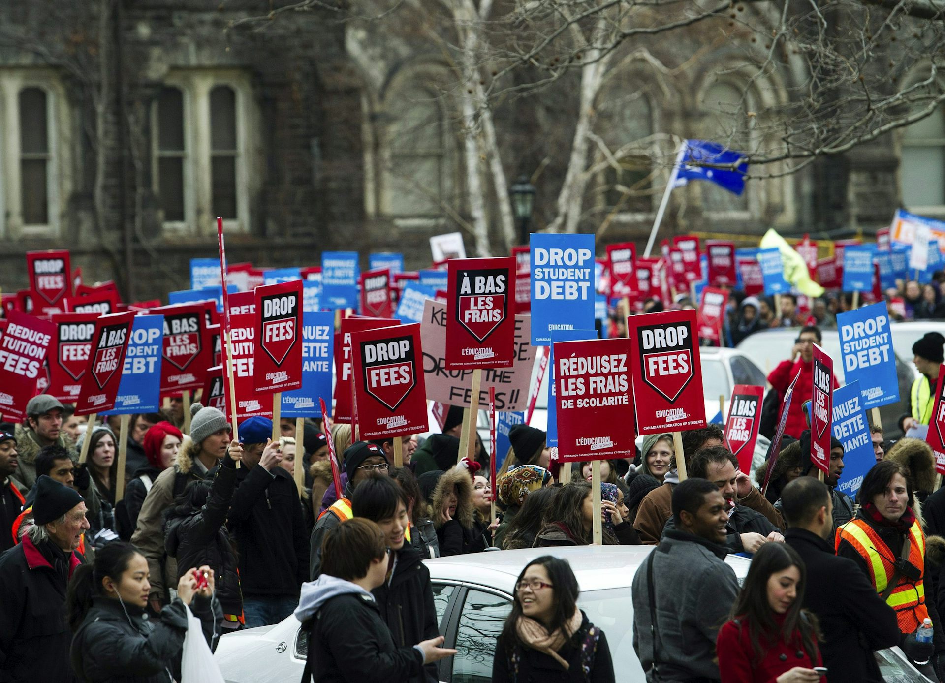 La gente porta carteles de protesta con lemas como alivio de la deuda estudiantil.
