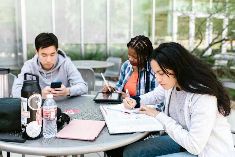 Students gather round a table to study.