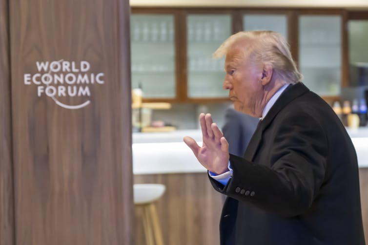 Side view of Trump waving as he leaves the World Economic Forum