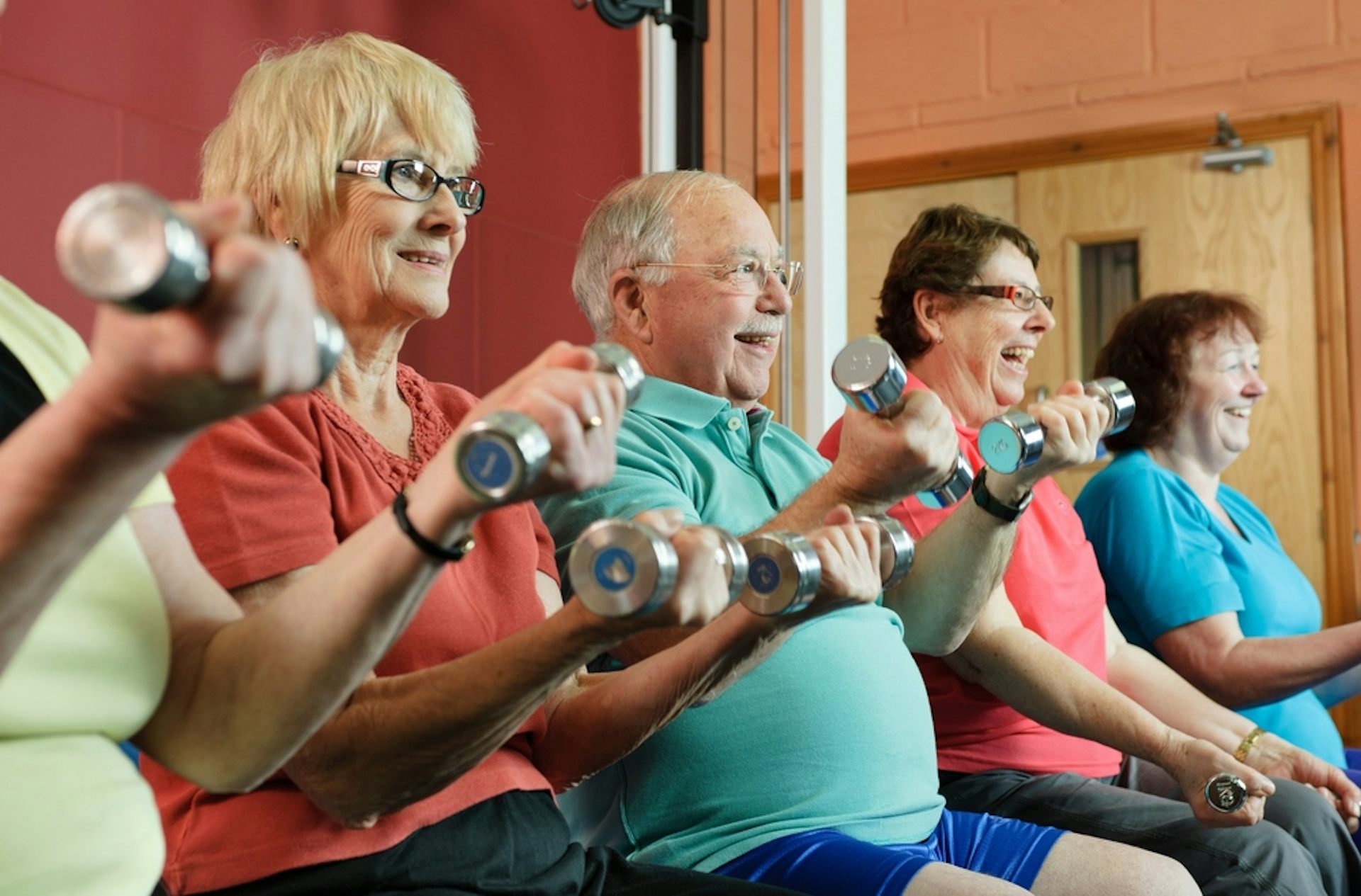 Older adults lifting light dumbbells.