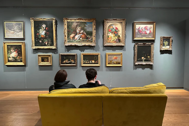 People sat on a sofa looking at paintings