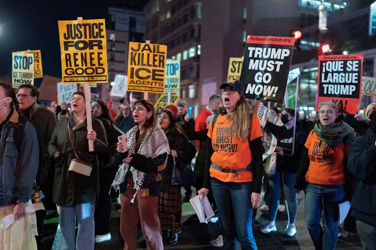 Las tácticas de inmigración de ICE sorprenden a más estadounidenses a medida que las operaciones fronterizas entre Estados Unidos y México avanzan hacia el norte 1 Varias personas sostienen carteles de protesta.