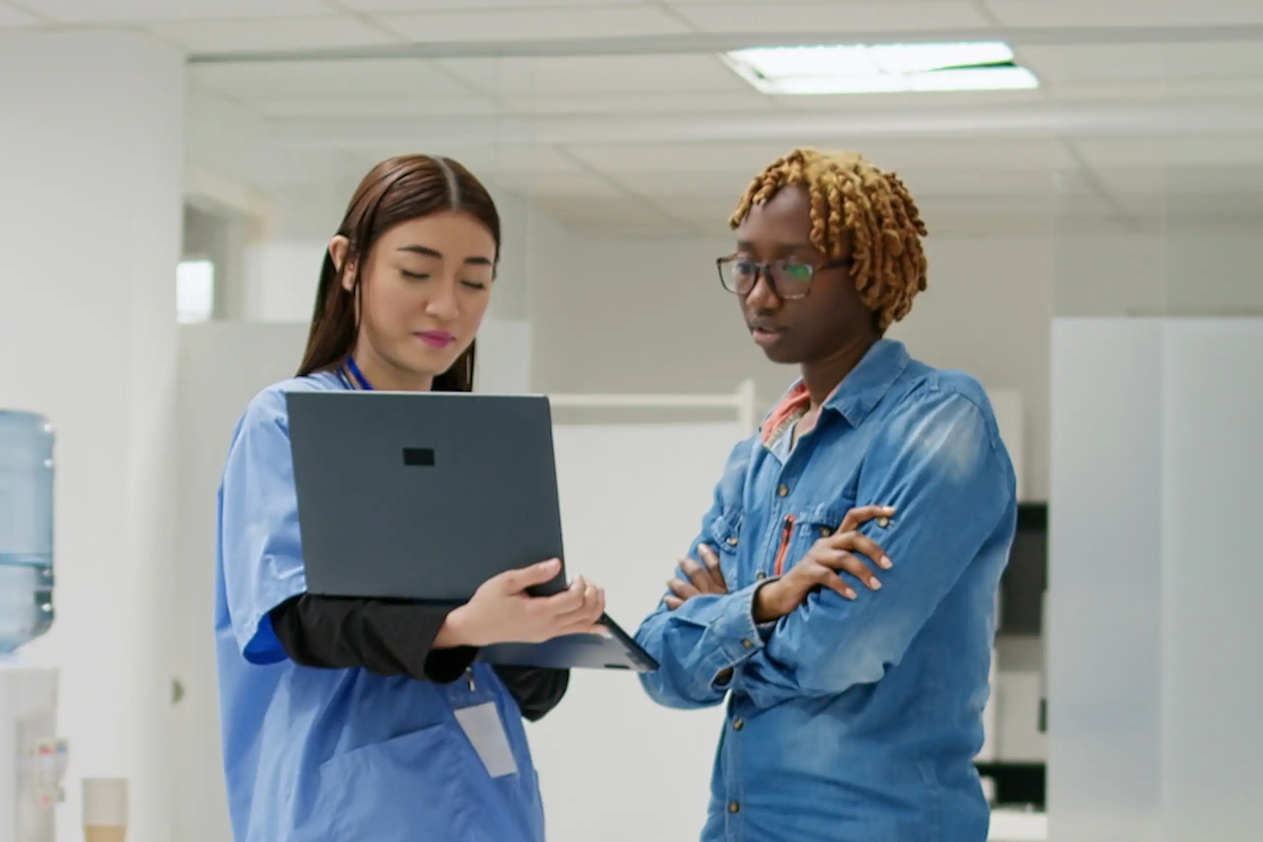 A health-care provider and a patient looking at a laptop screen