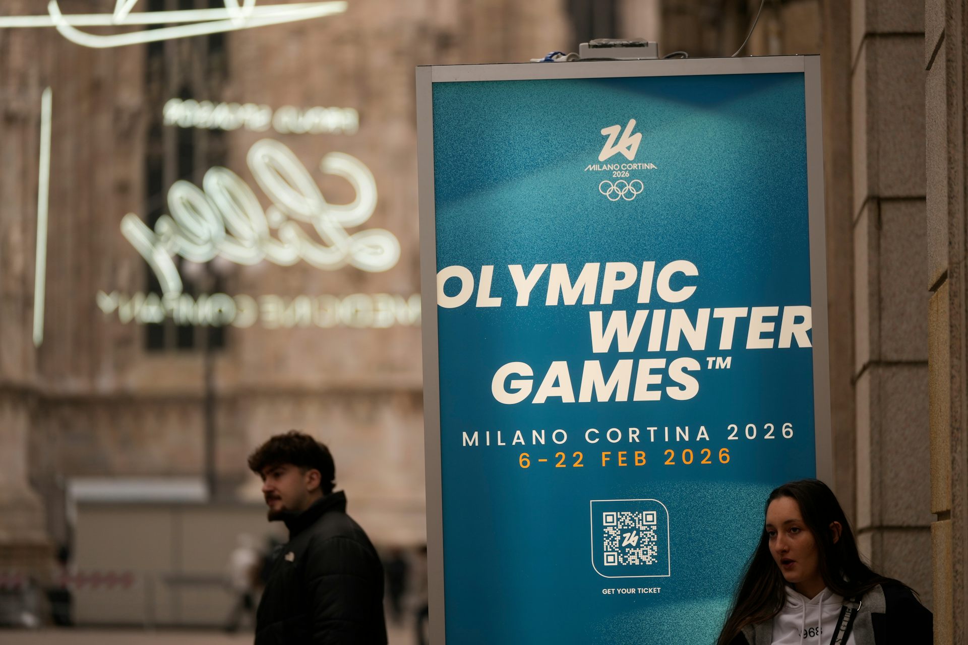 La gente pasa junto a un cartel que dice 